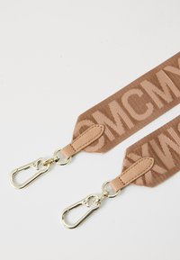 Tracolla in tessuto marrone con ganci in metallo color oro e grande testo beige parzialmente visibile su uno sfondo bianco.