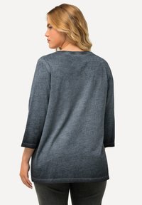 Top a maniche lunghe, modello rilassato, in gradiente di grigio. Tessuto morbido con una texture sottile, caratterizzato da un collo a barca e maniche a tre quarti.
