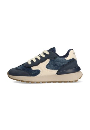 Baskets navy et crème avec une tige en denim texturé, accents en cuir contrastants, bout arrondi, lacets plats et semelle en caoutchouc de couleur claire.