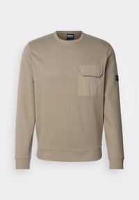 Sweatshirt de algodão bege com mangas longas, decote redondo, punhos e bainha canelados, e um bolso de retalho na parte frontal esquerda do peito.