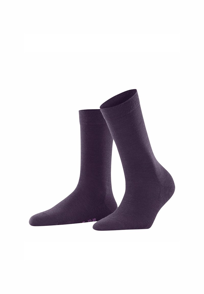 Deux chaussettes unies violettes, arrivant au mollet, se tenant droites sur un fond blanc.