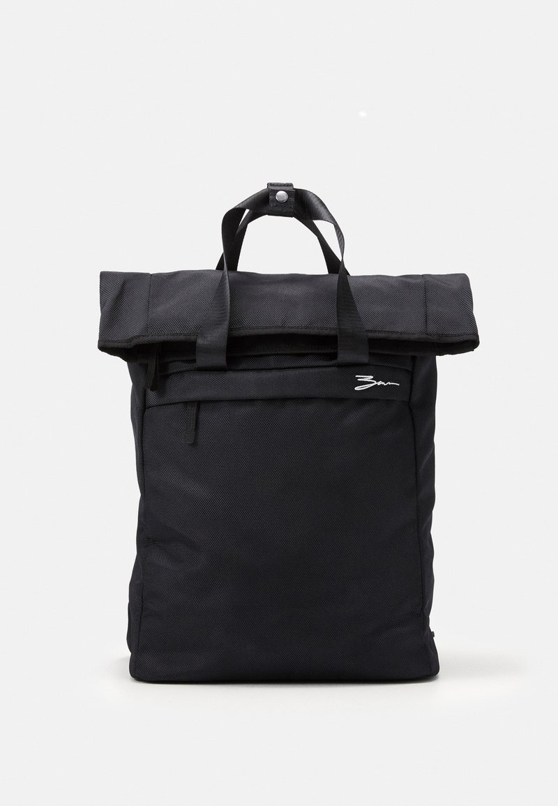 Sac à dos rectangulaire noir avec fermeture roll-top, double poignées de transport, poche avant zippée et petit logo blanc à l'avant.