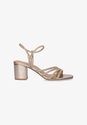 Sandalia dorada con tiras, tacón cuadrado, tiras adornadas con piedras de imitación y cierre de hebilla en el tobillo, adecuada para ocasiones formales o de noche.