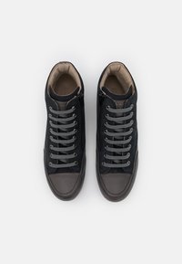 Sneakers in pelle blu scuro con lacci grigi, punta in gomma marrone e una fodera interna liscia, dotati di una cerniera laterale per una facile calzata.