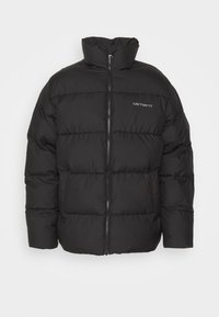 Sort polstret jakke med høj krave, med en forreste lynlås og vandret quiltning. Carhartt-logoet trykt på øverste venstre side.