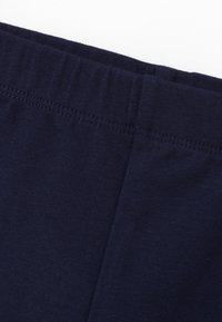 Tejido de algodón azul marino con una textura suave, una cintura elástica y un detalle de costura limpia a lo largo de los bordes.