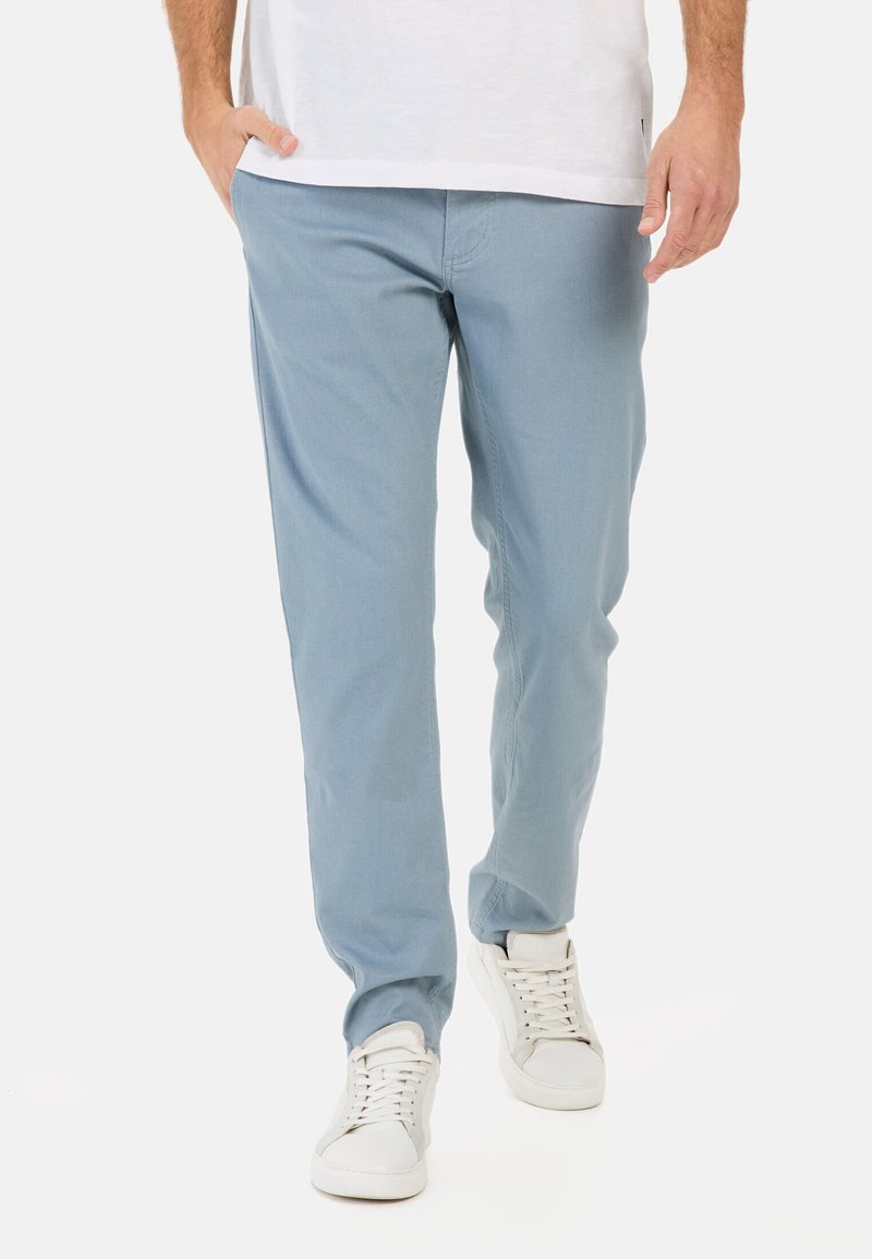 Lichtblauwe katoenen broek met een recht model en zichtbare stikdetails, gecombineerd met witte sneakers.