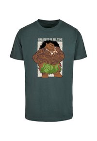 Dark green cotton T-shirt featuring a cartoon character with tattoos and a leaf skirt, text reads "GREATEST OF ALL TIME." Short sleeves, crew neck.