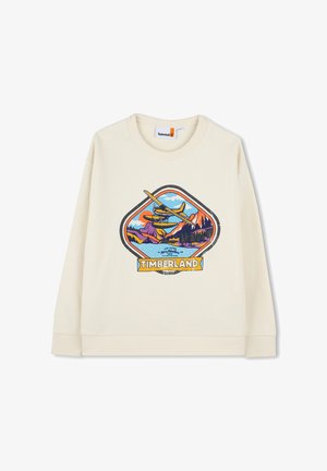 Sweatshirt couleur crème portant un logo graphique avec des montagnes, un lac et un avion, souligné par des accents bleus, orange et verts.
