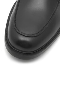 Czarne skórzane cholewki butów z okrągłym noskiem, gładką powierzchnią, akcentującymi szwami oraz kontrastującą krawędzią podeszwy dla dodatkowego detalu.