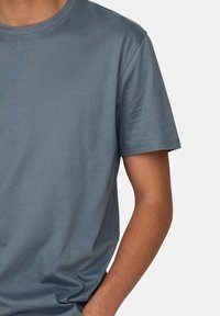 Short-sleeve t-shirt in a muted blue color, made of soft fabric. Features a rounded neckline and a relaxed fit.