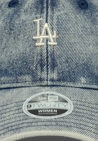 Denim bejzbol kapa svijetloplave boje s vezom "LA" u bijeloj. Ima zakrivljeni vizir i podesivu traku straga.