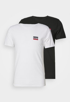 Duas t-shirts de manga curta, uma branca e uma preta, feitas de algodão. Cada uma apresenta um pequeno logótipo "Levi's" em vermelho e preto no peito.