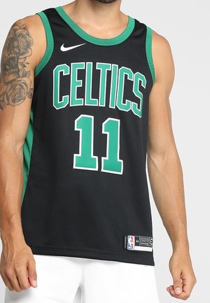 Homme portant un maillot de basket-ball Boston Celtics noir et vert avec le numéro 11 et un bras gauche tatoué.