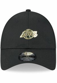 Black baseball cap featuring a gold Los Angeles Lakers logo on the front. Made of textured fabric with an adjustable strap at the back.