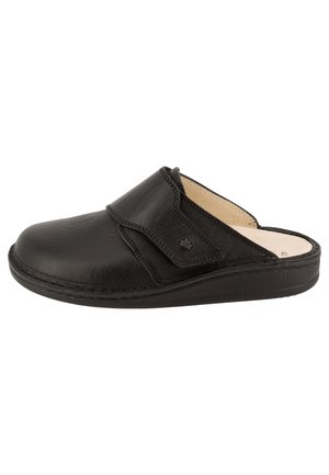 Zoccolo slip-on in pelle nera con punta arrotondata, cinturino regolabile nella parte superiore, suola imbottita e fodera interna beige.