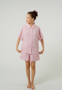 Pink striped short-sleeve shirt with a collar paired with matching shorts. The fabric appears soft and lightweight with a relaxed fit.