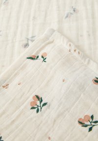 Tissu en coton à motifs floraux, de couleur crème avec des accents roses et verts, design en grille texturé, doux et léger.