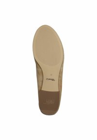 Beige suede shoe sole with a textured rubber bottom. Features a round toe, a slight heel, and embossed logo detailing near the arch.