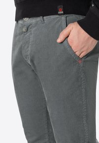 Grijze geweven broek met een gestructureerde afwerking, voorzien van een voorzak, subtiele merklabel en een slim fit ontwerp.