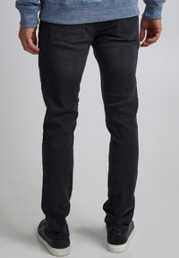 Svarta jeans i denim med slim fit, med detaljer i sömmen på bakfickorna och en jämn textur. Matchas med mörka sneakers.
