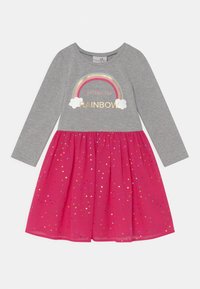 Šedé šaty s dlouhým rukávem s nápisem "follow the rainbow" a duhovou grafikou, s růžovou sukní ozdobenou vícebarevnými puntíky.