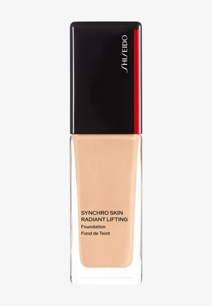 Shiseido Synchro Skin Radiant Lifting foundation in een heldere glazen fles met een zwarte dop en rode accent, met een gladde vloeibare textuur.
