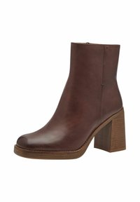 Bottines en cuir marron avec une pointe arrondie, fermeture éclair latérale et un talon en bois texturé. Détails de couture sur le dessus.
