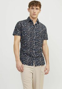 Camicetta a maniche corte in tessuto blu navy con motivo floreale bianco e corallo, chiusura a bottoni sul davanti e taglio dritto con spacchi laterali.