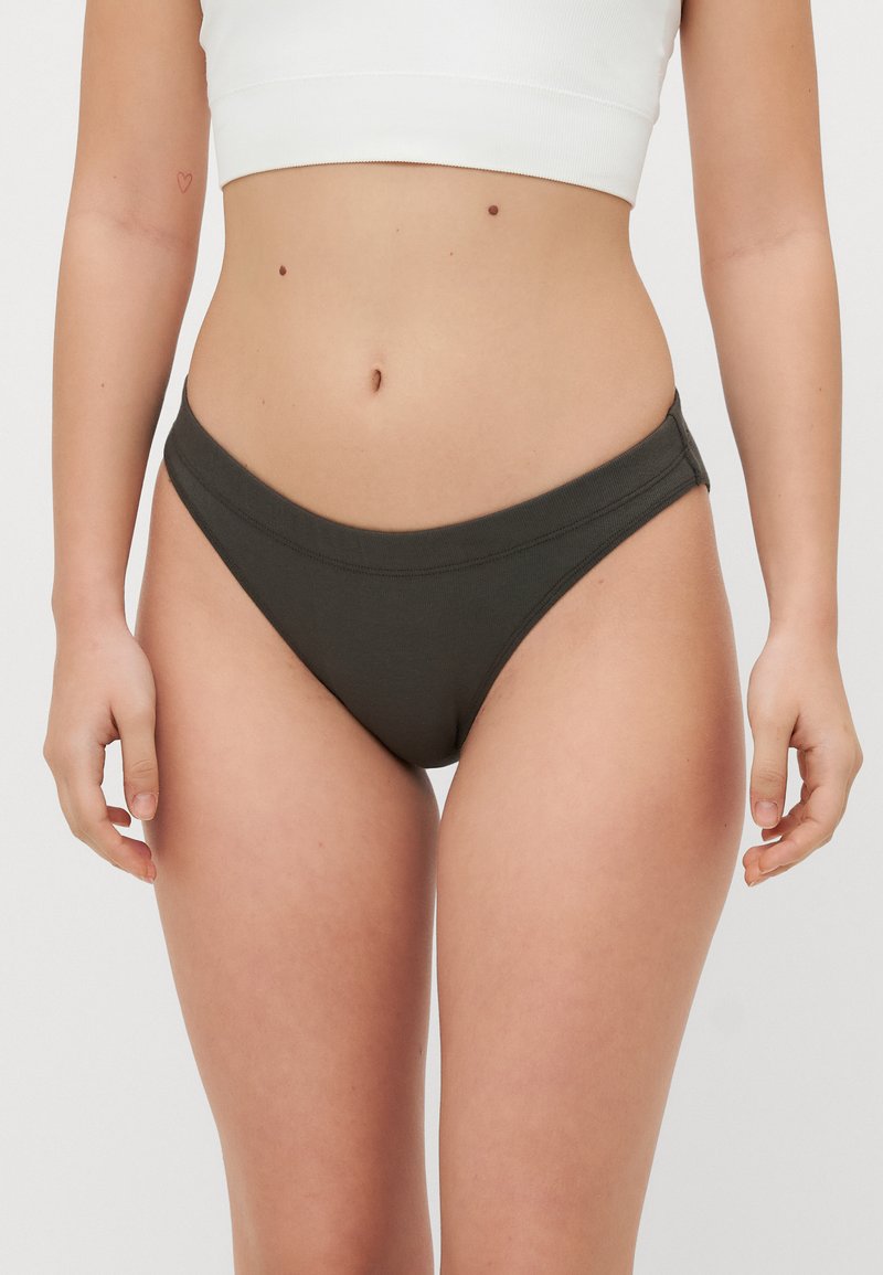 Donker groene bikinibroekjes van zacht materiaal met een gladde textuur, met een laag uitgesneden model en een brede elastische tailleband.