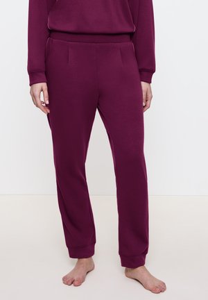 Burgundy sweatpants i mjuk tyg med avslappnad passform. Har sidofickor, elastisk midja och smalnande cuffar vid anklarna.