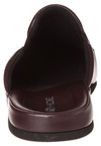 Burgundowe skórzane buty wsuwane o gładkiej powierzchni, zaokrąglonym kształcie i wyściełanej wkładce. Wnętrze wyłożone, z płaską czarną podeszwą.