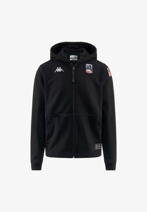 Felpa nera con cappuccio e zip, realizzata in tessuto morbido, con un logo sul petto, la bandiera degli Stati Uniti sulla manica e due tasche nella parte frontale.