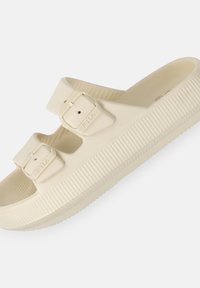 Beiga sandaler med två justerbara remmar och spännen. Tillverkade av texturerat material, med en räfflad sula för grepp och komfort.