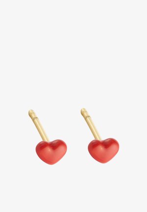 Boucles d'oreilles en métal doré avec des accents en plastique en forme de cœur rouge, présentant une texture lisse et un design simple et courbé.