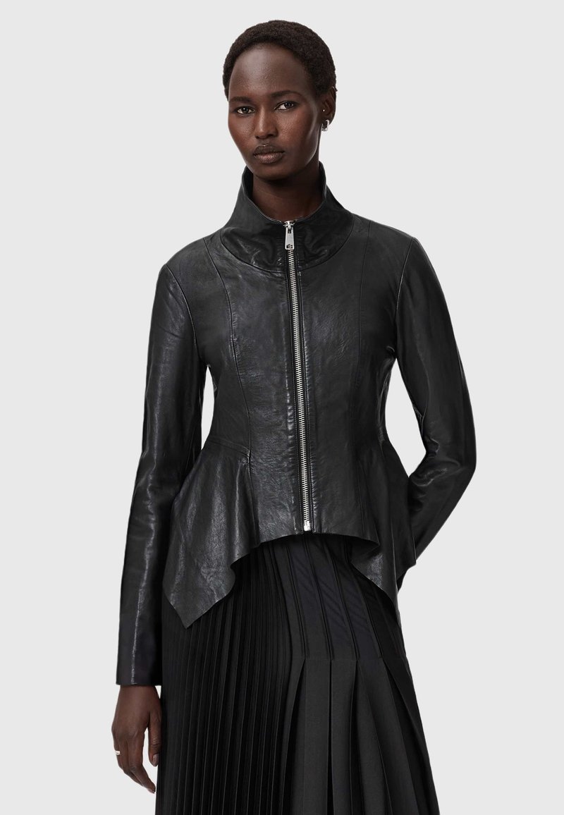 Schwarze Lederjacke mit hohem Kragen und Peplum-Saum. Verfügt über einen Reißverschluss auf der Vorderseite und eine glatte Textur, kombiniert mit einem gefaltetem schwarzen Rock.