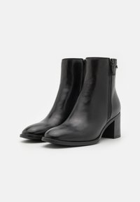 Schwarze Lederstiefeletten mit glatter Oberfläche, seitlichem Reißverschluss und runder Zehenform. Blockabsatz für Stabilität.