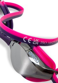 Lunettes de natation avec des sangles roses et violettes affichant les marques CE et UKCA et la certification ISO 18527-3 sur la sangle.