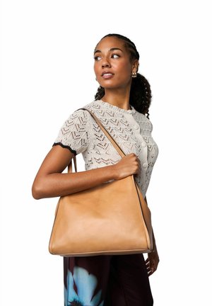 Tanfarvet lædertaske med trekantet form og glat tekstur, med en enkelt skulderrem og minimalistiske syningsdetaljer.