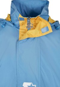 Jachetă albastră deschis cu un guler galben. Are un fermoar, șnururi ajustabile și un accent cu logo. Textură netedă cu un design modern.