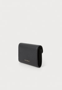 Black textured leather wallet with a fold-over design, featuring a gold logo. Compact shape with visible stitching and smooth edges.