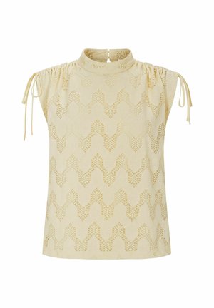 Bež brezrokavna bluza z visokim ovratnikom, čipkasto cikcak vzorcem in nastavljivimi vezalkami na ramenih na belem ozadju.