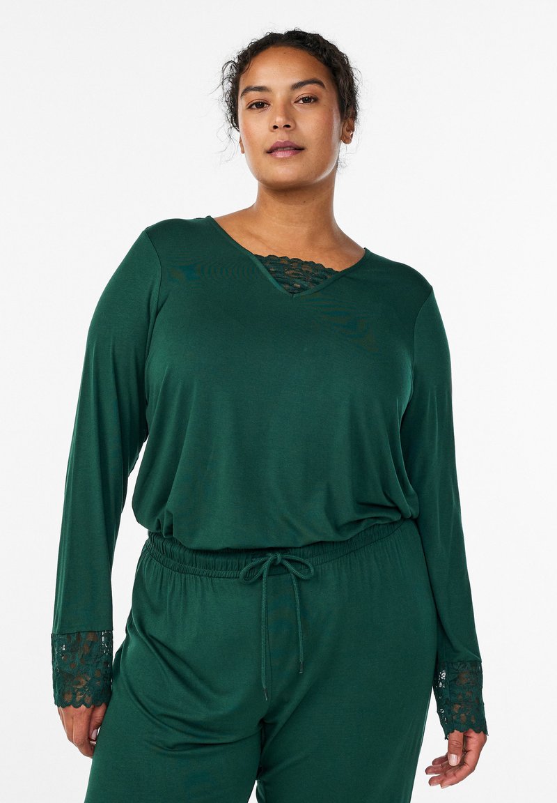 Temno zelena sprostitvena obleka z dolgimi rokavi, okrašenimi s čipko na manšetah, in čipkastim vložkom na izrezu, zaključena z elastičnim pasom s trakcem za prirezovanje.