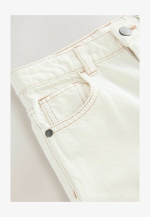 Pantaloni in cotone color crema con una finitura texturizzata, dotati di cuciture arancioni a contrasto e una tasca laterale con un accento in rivetto metallico.