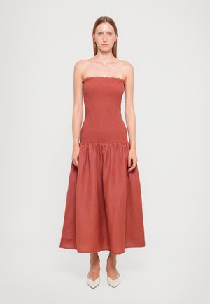 Stroppeløs, rustfarget kjole med smock-bodice, utsvingt bunn og volangdetalj ved halsen. Glatt tekstur, knelengde.