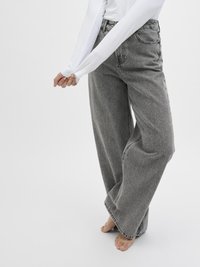 Gray wide-leg jeans with a high waist, featuring a faded texture, five pockets, and a button-fly closure. Paired with a white long-sleeve top.