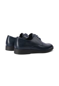 Zapatos de vestir de cuero azul marino con un acabado suave, punta redondeada y diseño de cordones. Suela de goma con patrones de tracción sutiles.