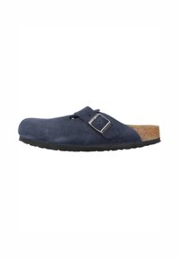 Zoccoli in suede blu navy con soletta in sughero, aperti sul retro e con cinturino regolabile dotato di fibbia metallica. Suola in gomma per garantire aderenza.