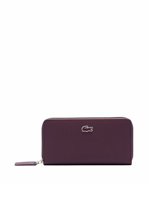 Cartera rectangular morada con cierre de cremallera alrededor, superficie texturizada, logo de cocodrilo plateado centrado y tirador de cremallera morado a juego.
