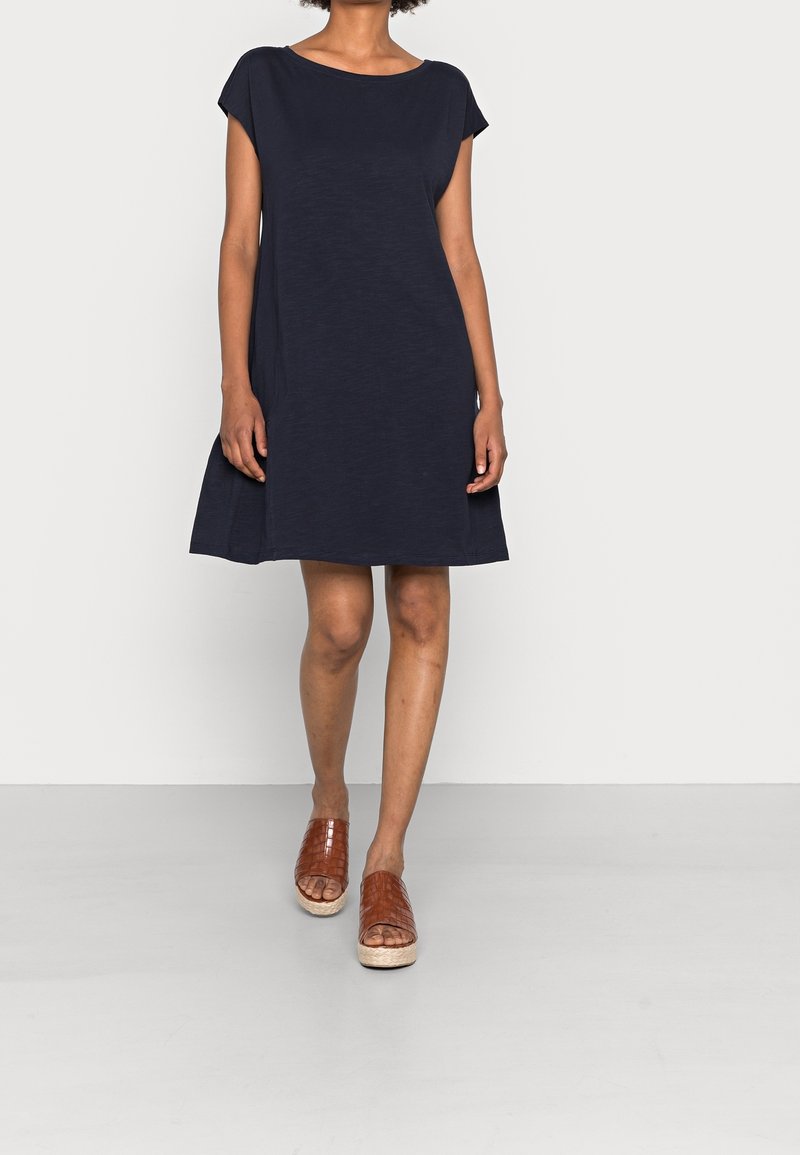 Sinih el dress lyhyillä hihoilla, rento malli ja levenevä helma. Kevyestä kankaasta valmistettu, yhdistetty ruskeisiin kudottuihin liukuvaatteisiin.